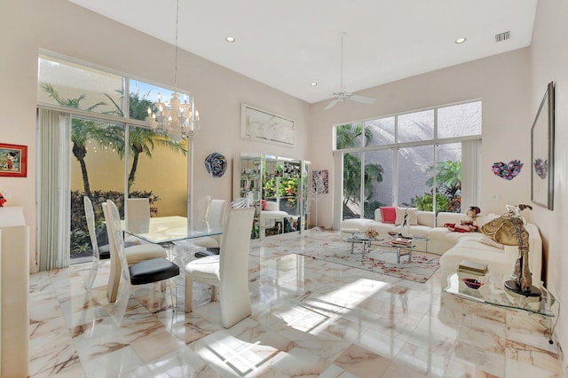 dining area featuring ceiling fan with notable chandelier