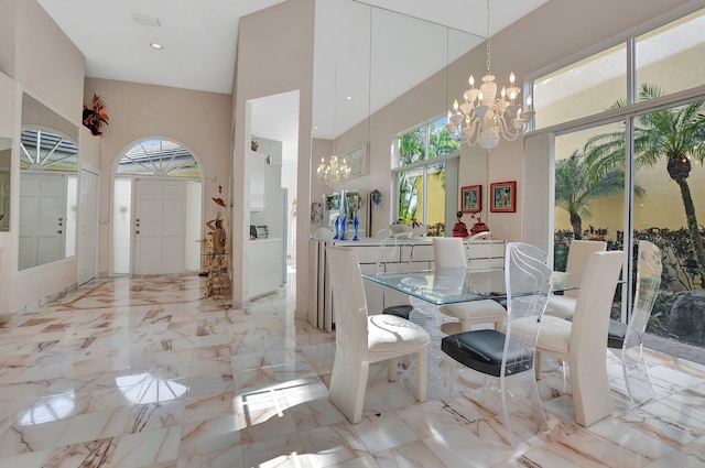 dining area with a high ceiling and a notable chandelier