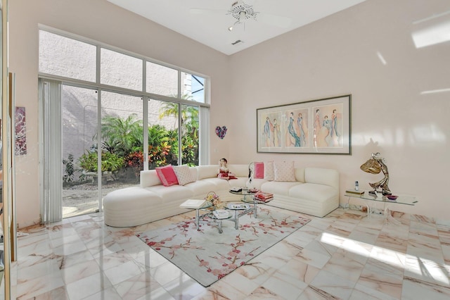 unfurnished living room with ceiling fan and a towering ceiling