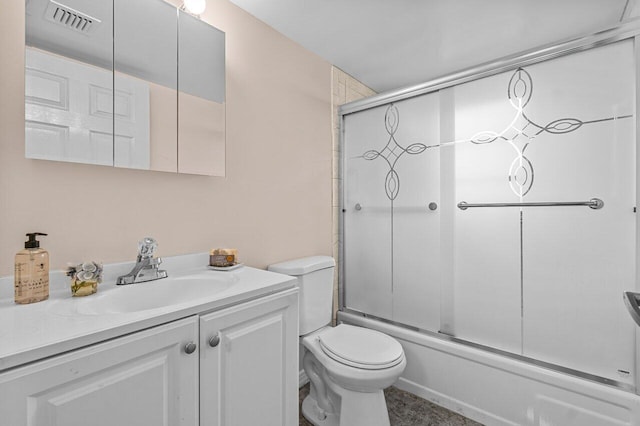 full bathroom featuring vanity, bath / shower combo with glass door, and toilet