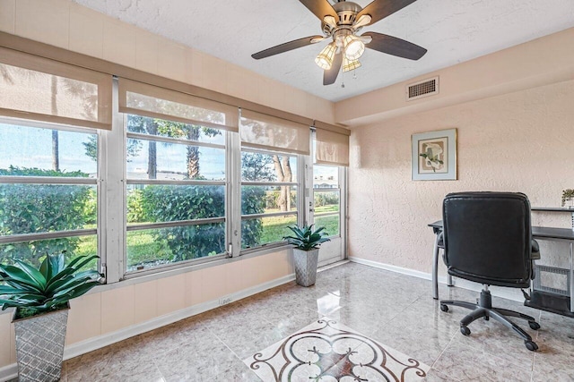 home office with a wealth of natural light, ceiling fan, and a textured ceiling