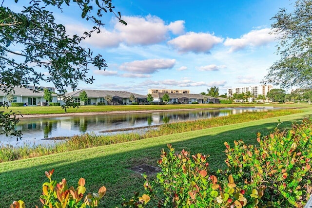 view of community with a lawn and a water view