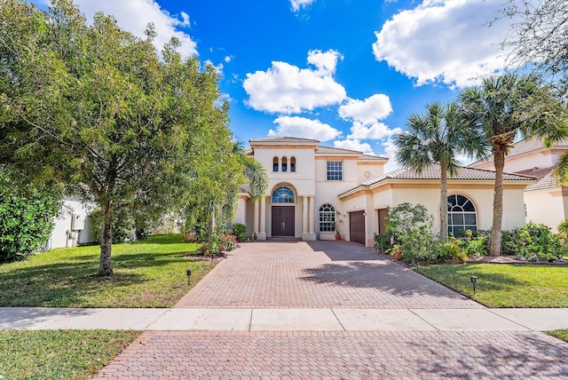 mediterranean / spanish home with a front lawn