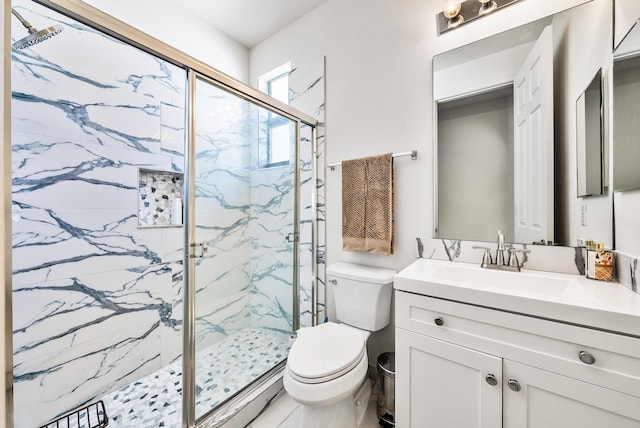 bathroom with vanity, toilet, and a shower with shower door