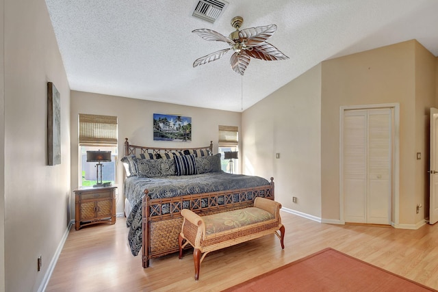 bedroom featuring multiple windows, a textured ceiling, light hardwood / wood-style flooring, and ceiling fan