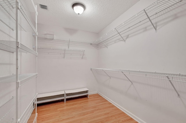 spacious closet with hardwood / wood-style floors