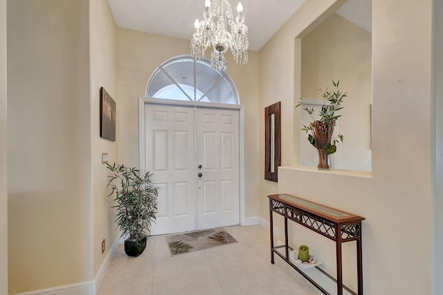 tiled foyer featuring an inviting chandelier