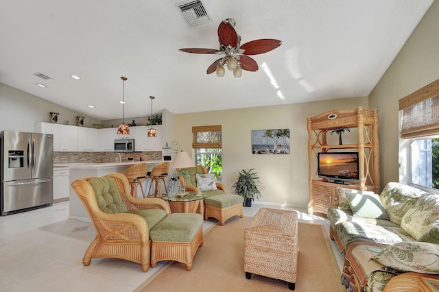 living room featuring vaulted ceiling, plenty of natural light, and ceiling fan