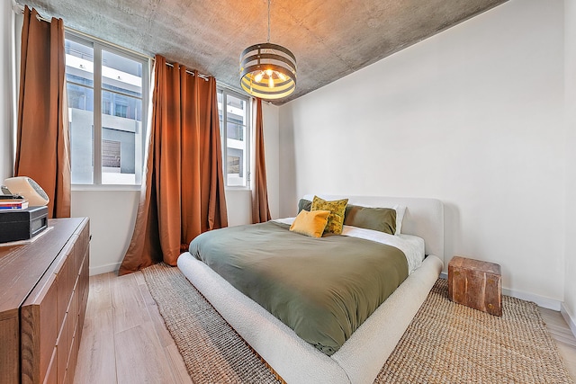 300 S Australian Ave Unit 520, West Palm Beach, FL 33401 - bedroom with light wood-type flooring, a chandelier, and baseboards