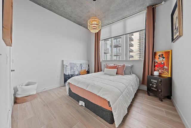 bedroom with light wood-style floors and baseboards