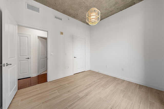 300 S Australian Ave Unit 520, West Palm Beach, FL 33401 - empty room featuring light wood-style flooring, a chandelier, and baseboards