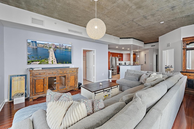 living room with visible vents, baseboards, and dark wood-style floors