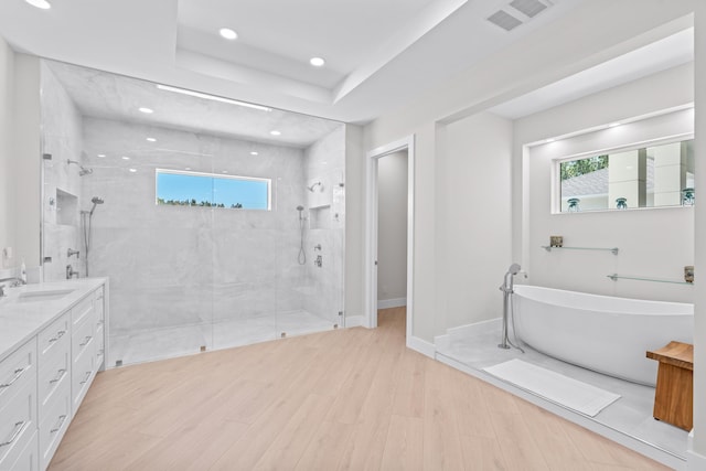 bathroom with vanity, hardwood / wood-style flooring, independent shower and bath, and a healthy amount of sunlight