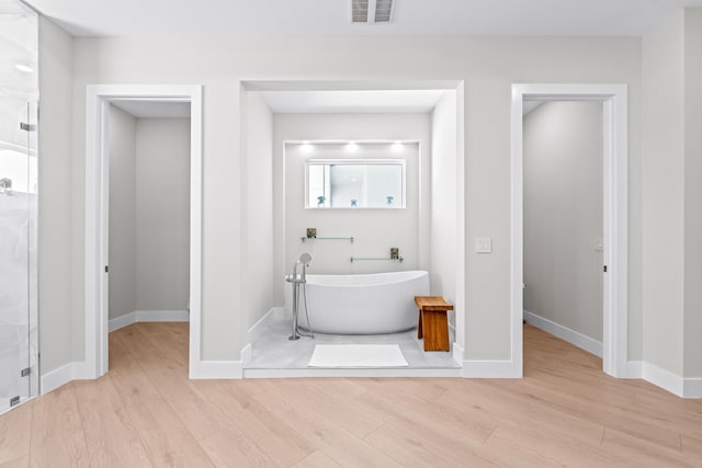 bathroom with hardwood / wood-style floors and shower with separate bathtub