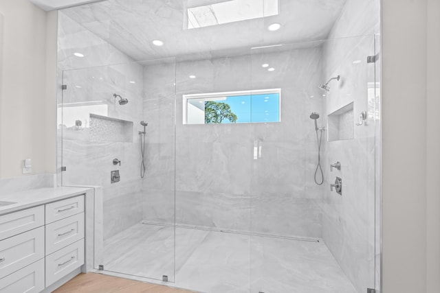 bathroom with vanity, hardwood / wood-style flooring, and a shower with door