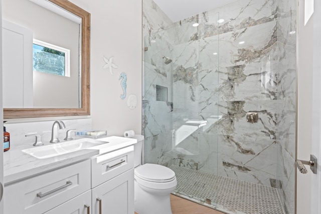 bathroom with hardwood / wood-style floors, vanity, toilet, and a shower with door