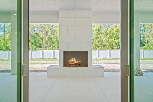 doorway to outside with a fireplace and concrete floors