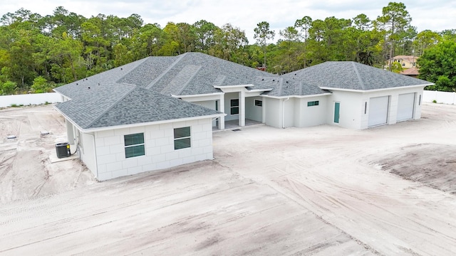 exterior space with a garage and cooling unit