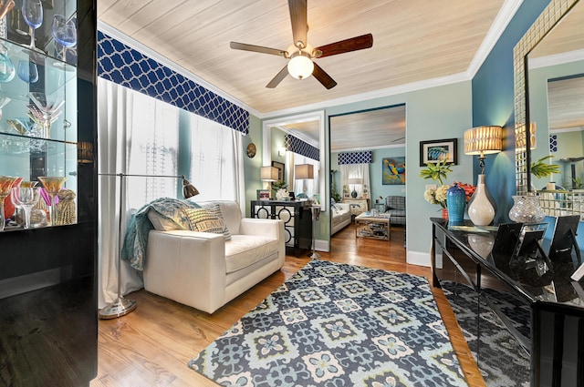 living area featuring wooden ceiling, crown molding, ceiling fan, and wood-type flooring