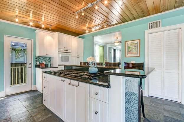 kitchen featuring decorative backsplash, white cabinetry, wooden ceiling, and stainless steel gas cooktop