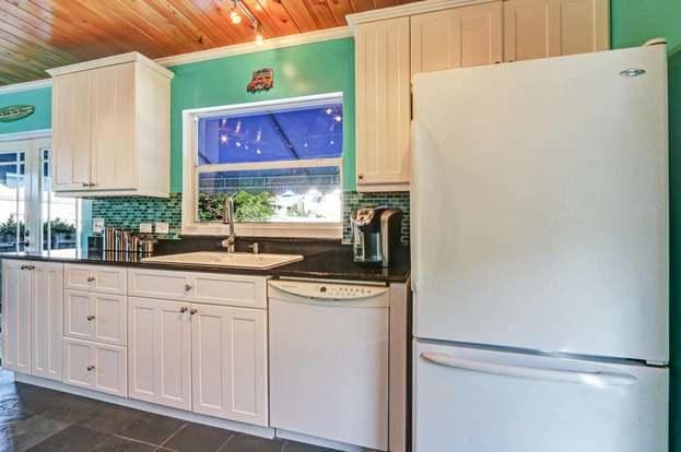 kitchen with white appliances, backsplash, wooden ceiling, and sink