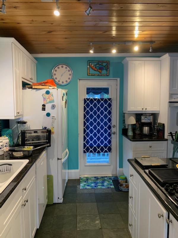 kitchen featuring white appliances, crown molding, sink, wooden ceiling, and white cabinetry