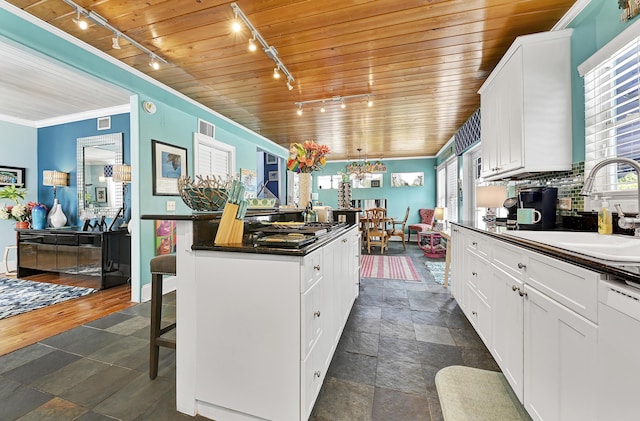 kitchen featuring wooden ceiling, white cabinets, and a healthy amount of sunlight