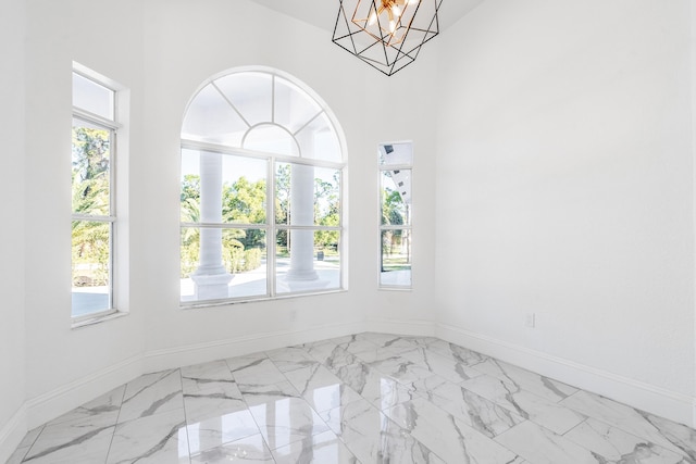 unfurnished room featuring a chandelier