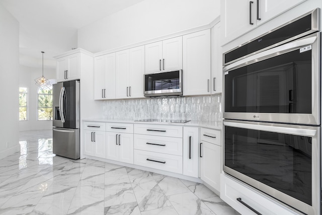 kitchen with decorative light fixtures, white cabinetry, appliances with stainless steel finishes, and tasteful backsplash