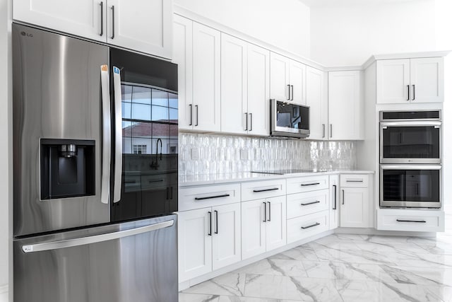 kitchen featuring decorative backsplash, white cabinetry, and appliances with stainless steel finishes