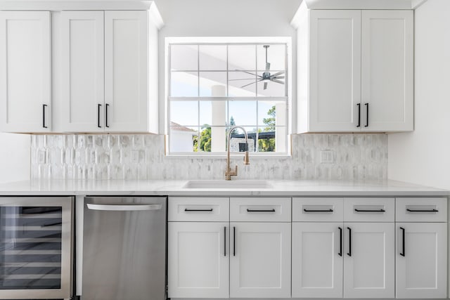 kitchen with dishwasher, white cabinets, sink, decorative backsplash, and beverage cooler