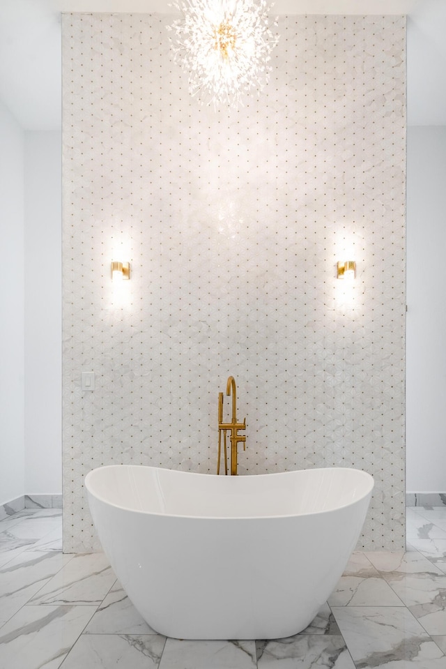 bathroom with a tub, tile walls, and an inviting chandelier