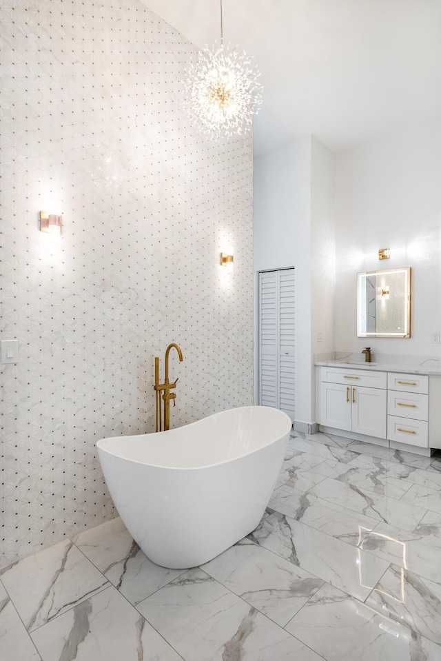 bathroom featuring a tub to relax in, vanity, a chandelier, and tile walls