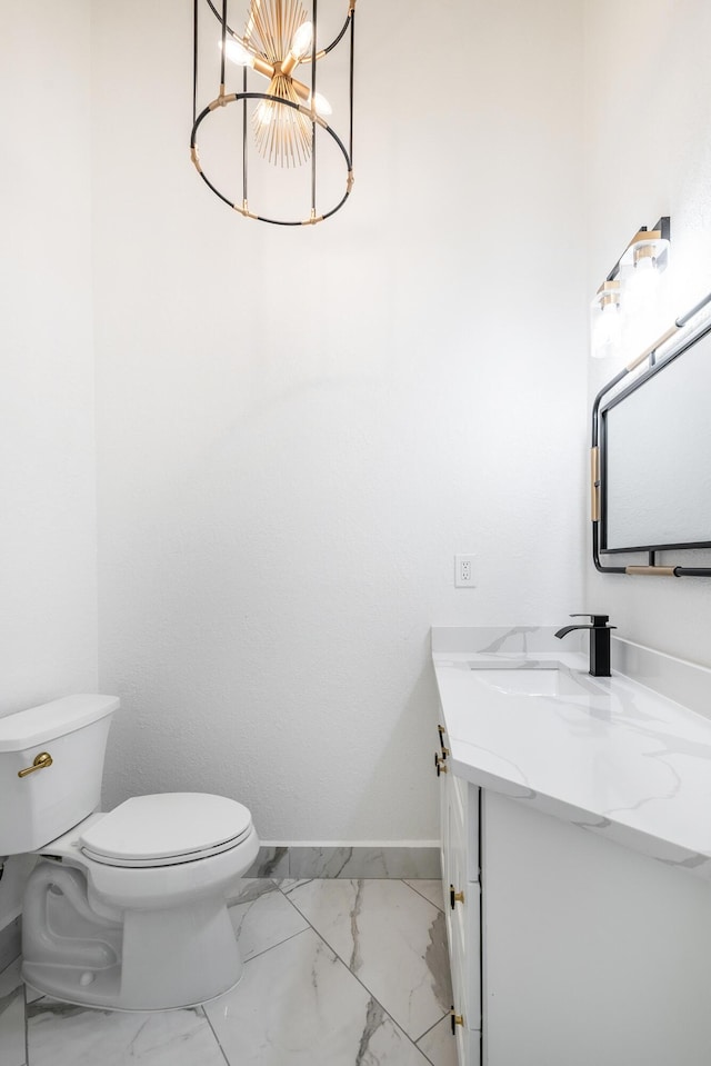 bathroom with vanity, a chandelier, and toilet