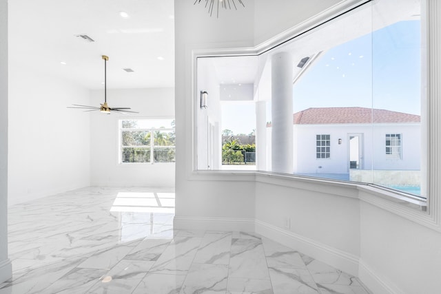 spare room with a wealth of natural light and ceiling fan