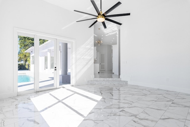 empty room with ceiling fan and high vaulted ceiling