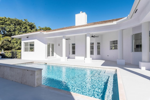 view of swimming pool featuring ceiling fan, a patio area, and french doors