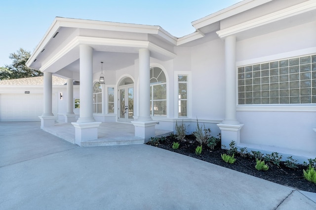 view of exterior entry with a porch and a garage