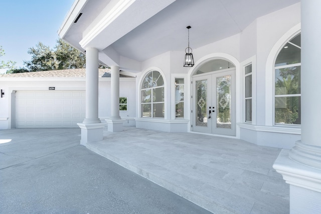 view of patio / terrace featuring french doors and a garage