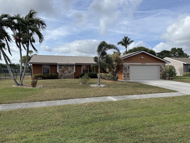 single story home featuring a garage and a front lawn