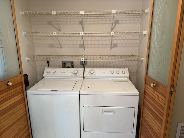 laundry room with laundry area, visible vents, and separate washer and dryer