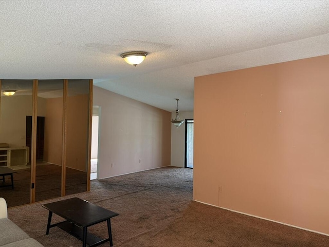 unfurnished living room with lofted ceiling, carpet, and a textured ceiling