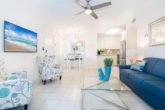 living room with light tile patterned floors and ceiling fan with notable chandelier