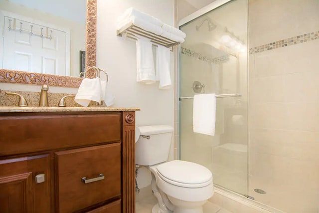 bathroom featuring tile patterned floors, vanity, toilet, and walk in shower