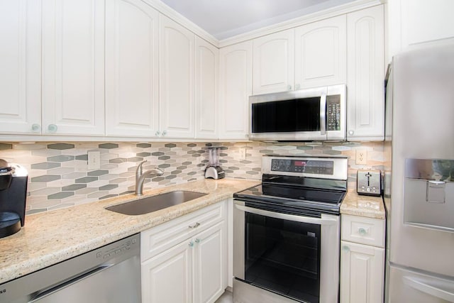 kitchen featuring appliances with stainless steel finishes, white cabinetry, and sink