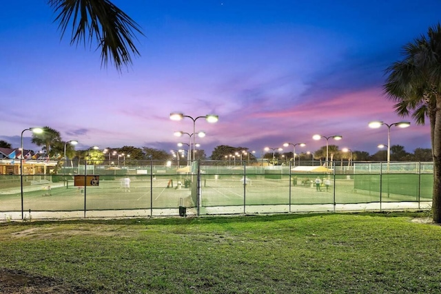 view of tennis court featuring a yard