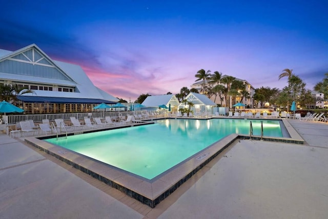 pool at dusk featuring a patio