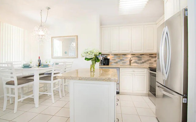 kitchen featuring backsplash, sink, hanging light fixtures, appliances with stainless steel finishes, and white cabinetry