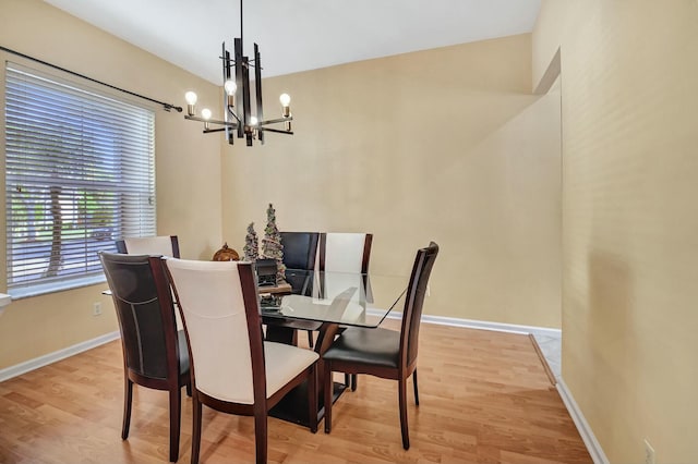 dining room featuring light wood-type flooring and a chandelier