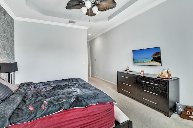 bedroom with a raised ceiling, ceiling fan, crown molding, and light carpet